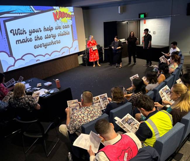 A group of presenters speaking to an audience of people.