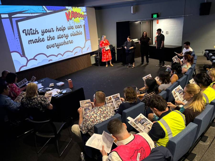 A group of presenters speaking to an audience of people.
