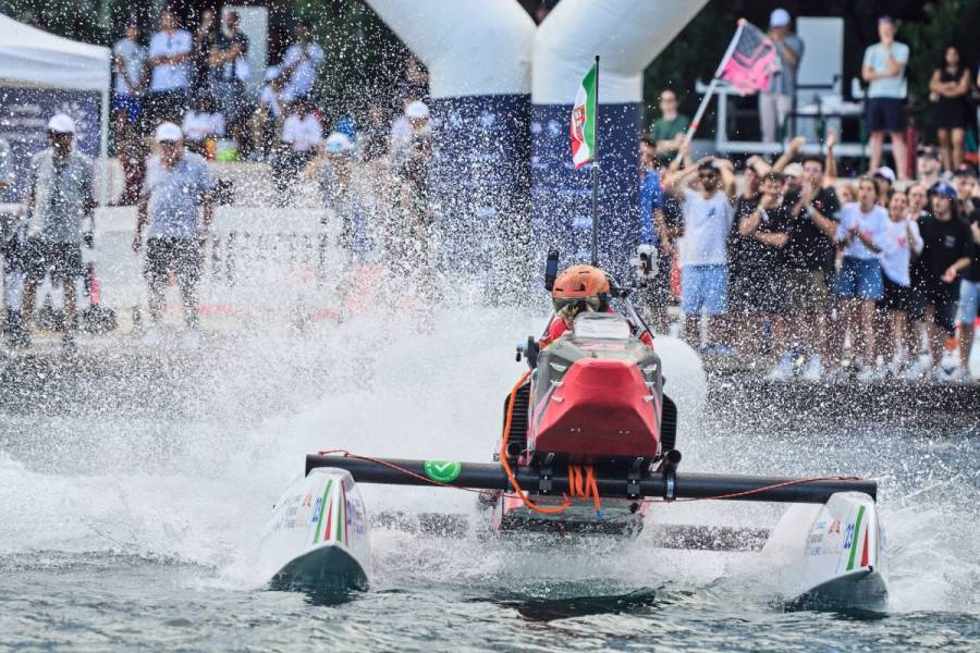 A participant speeds through water on an electric speed boat during the Monaco Energy Boat Challenge as spectators watch from the shore.